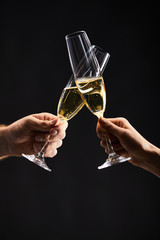 cropped view of man and woman clinking with champagne glasses and celebrating christmas, isolated on black