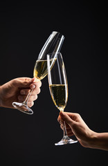 cropped view of couple clinking with champagne glasses and celebrating christmas eve, isolated on black