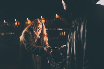 Thief Dangerous man or masked robber with knife attacking shoulder bag. Robber or thief holding knife burglarize to steal the money wallet in bag, while standing near her car and don't