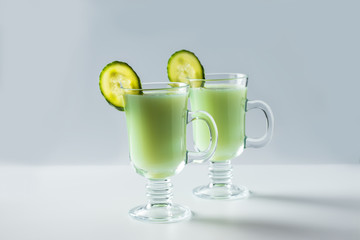 Kefir, greens and cucumber smoothie, a sour-milk drink. On white background.