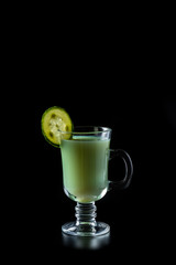 Kefir, greens and cucumber smoothie, a sour-milk drink. On a black background.