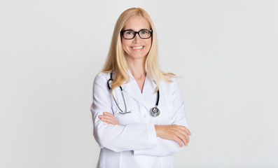 Smiling medical physician doctor posing on grey background - obrazy, fototapety, plakaty