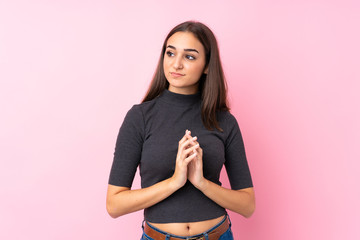 Young girl over isolated pink background scheming something