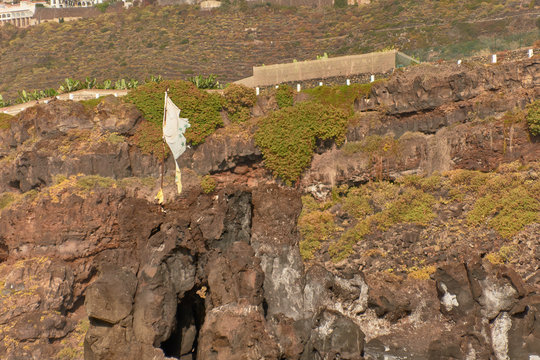 Canary flag on top of a cliff at Playa del Bohio in Tenerife North, Canary Islands