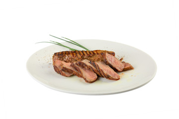 hot fresh grilled boneless rib eye steak on white plate with barbecue grill marks in the meat