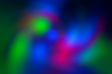 Green, pink, blue, blurry christmas and holiday lights. Multicolored, bright blurred spiral vortex gradient background