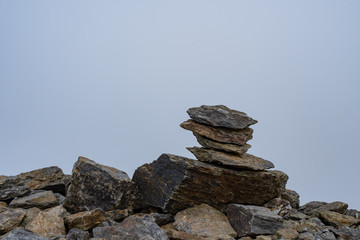 stacked stones on a mountain trail. Piramida. marker Hiking trails in the fog. Difficulties of tourism. The bad weather conditions.
