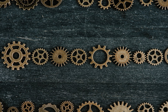 flat lay with vintage metal gears on dark wooden background © LIGHTFIELD STUDIOS