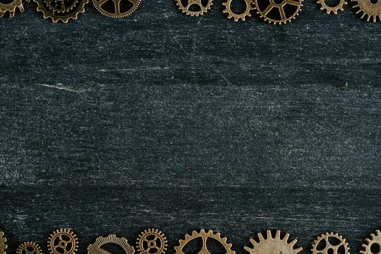 borders of vintage metal gears on dark wooden background with copy space © LIGHTFIELD STUDIOS