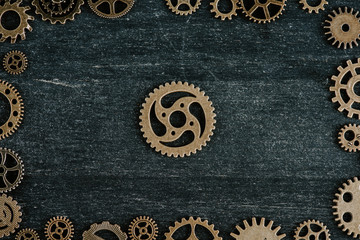 top view of vintage metal gears arranged in frame on dark wooden background
