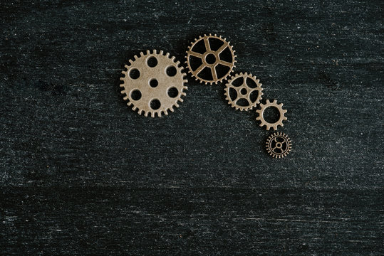 top view of retro metal gears on dark wooden background with copy space © LIGHTFIELD STUDIOS