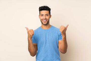 Fototapeta premium Young handsome man over isolated background with thumbs up gesture and smiling