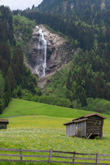 Waterfall and old cabin huts in Austria