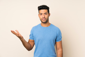 Fototapeta premium Young handsome man over isolated background making doubts gesture