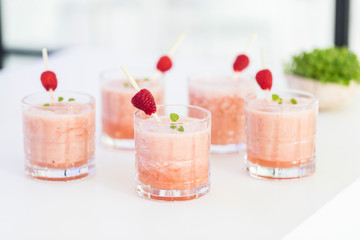 Fresh pink raspberry smoothie served in a glas