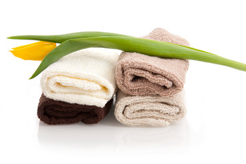 Brown face towels and yellow tulips on white background