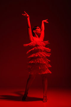 Beautiful Dancer In Dress With Fringe Dancing Tango On Dark Background With Red Illumination