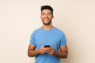 Young handsome man over isolated background surprised and sending a message