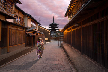 Kyoto, Japan - November 4 2018: A woman dressed like a Maiko (apprentice geisha) taking a photo of Yasaka Pagoda of Hokan-ji temple, a temple in a traditional street in Higashiyama-ku, Gion, Kyoto