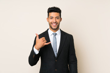 Young handsome businessman man over isolated background making phone gesture