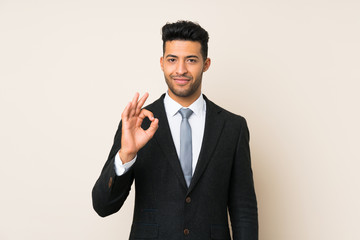Young handsome businessman man over isolated background showing an ok sign with fingers