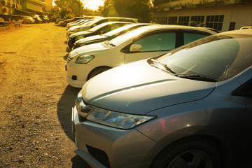 Close Up of front side of cars in outdoor parking area in morning sunshine day.