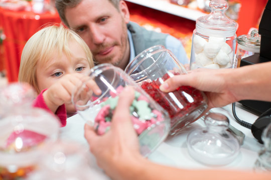 Child Grabbing Some Sweets Out Of A Jar In The Candy Store