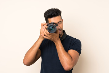 Fototapeta premium Young handsome man over isolated background with a professional camera