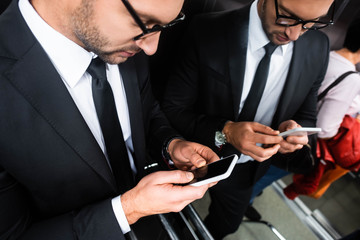 cropped view of businessman in suit using smartphone in elevator © LIGHTFIELD STUDIOS