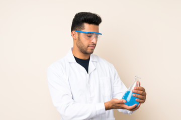 Young handsome man over isolated background with a scientific test tube