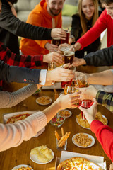 Happy co-workers celebrating while company party and corporate event. Young caucasian people in casual clothes cheering and laughting. Concept of office culture, teamwork, friendship, holidays