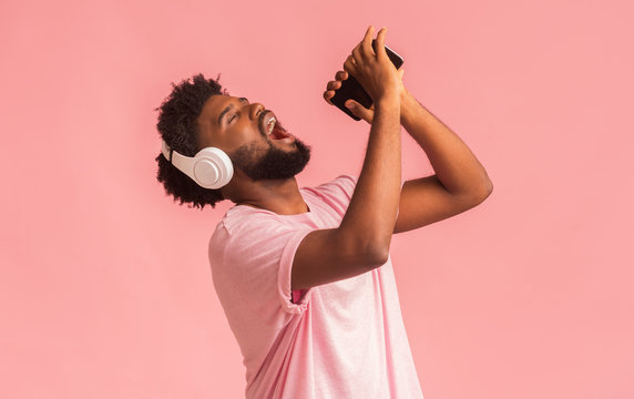 Emotional black man singing his favorite song on smartphone
