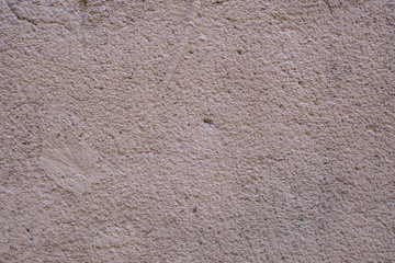 Concrete wall painted pink - gray. Rough texture, background.