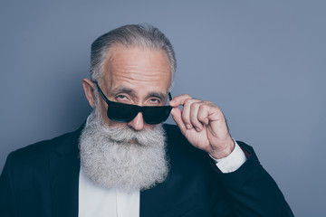 Close-up portrait of his he nice attractive chic classy brutal arrogant serious gray-haired man putting of specs looking at you isolated over dark grey pastel color background