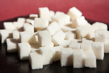 White sugar cubes on black with red background