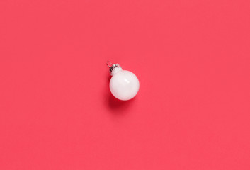 White Christmas bauble on a pink background