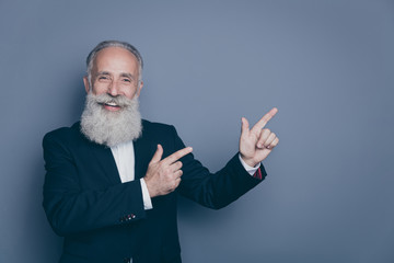 Close-up portrait of his he nice attractive cheerful cheery gray-haired man pointing two...