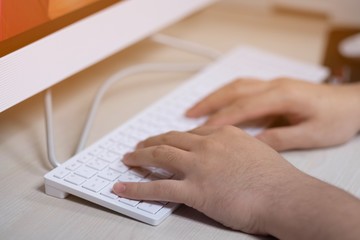 The office man typing something on white computer keyboard in office