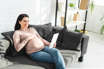 pregnant woman having online consultation with doctor on digital tablet at home