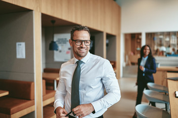 Smiling mature businessman walking through a modern office