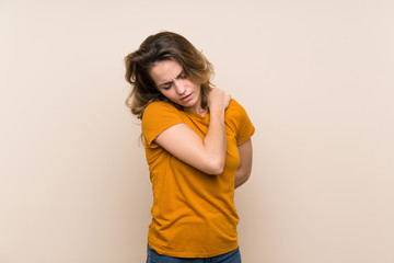 Young blonde girl over isolated background suffering from pain in shoulder for having made an effort