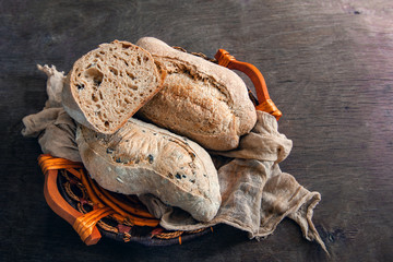 Healthy rye wholegrain bread in a brown Kraft basket on a farmer's wooden table. Homemade cake