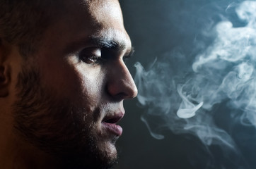 Man Vaping an Electronic Cigarette. Vaper Hipster Smoke Vaporizer and Exhals Smoke Cloud.