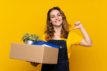 Young blonde girl making a move while picking up a box full of things proud and self-satisfied