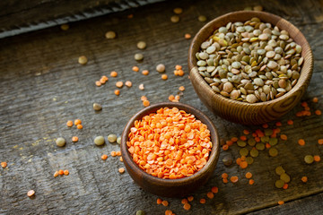 Healthy food, dieting, nutrition concept, vegan protein source. Raw legumes - red lentils and canadian lentils on wooden table. Copy space.