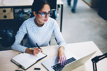 Skilled business woman wear spectacles for vision protection looK at laptop computer monitor during...