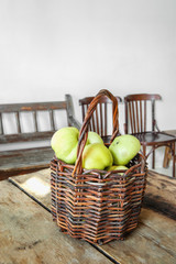 Green apples in an old crafting basket on an old wooden table are ready for processing. Copy space