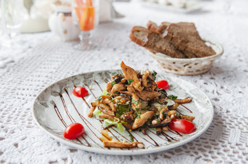 Delicious chanterelle mushroom salad with chicken breast beans and tomatoes warm. Close-up, restaurant serving.