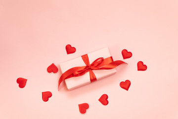 Valentine's Day. Pink gift box with red bow , love red shape on pink background. Flat lay, top view, copy space.