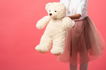 cropped view of woman holding teddy bear isolated on pink